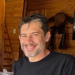 foto  de perfil, hombre  sonriendo vestido con camiseta negra.
