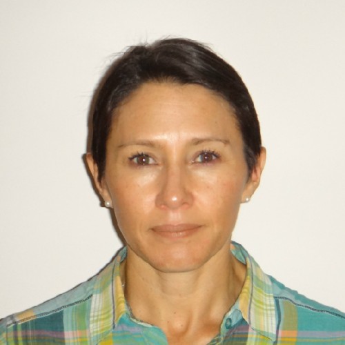 Foto de perfil mujer con pelo corto, piel morena, camisa con cuadros verdes.